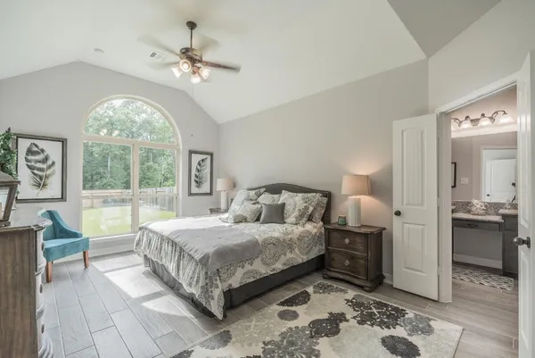 a spacious bedroom with a large bed and a chandelier