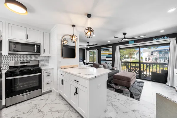 a kitchen with a stove a oven a dining table and chairs with wooden floor