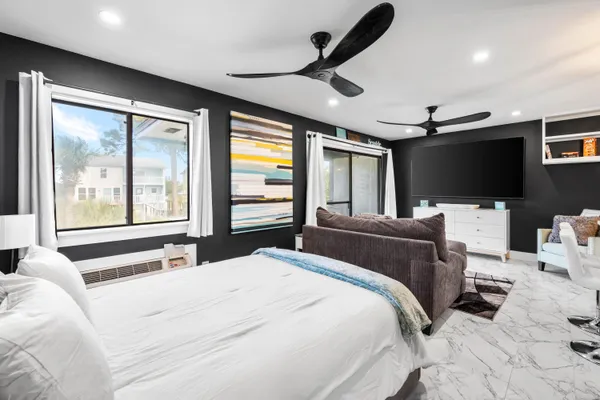 a bedroom with a bed window and flat screen tv