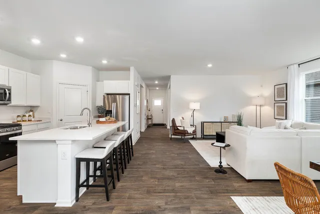 a kitchen with stainless steel appliances a sink stove refrigerator and cabinets
