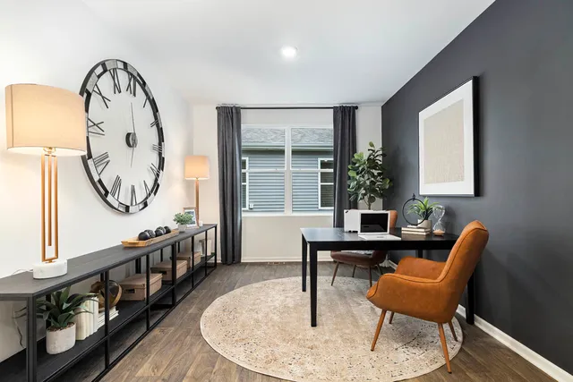 a view of a livingroom with furniture mirror wooden floor and a window