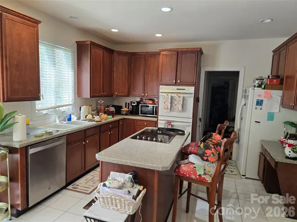 a kitchen with granite countertop a sink stainless steel appliances and cabinets