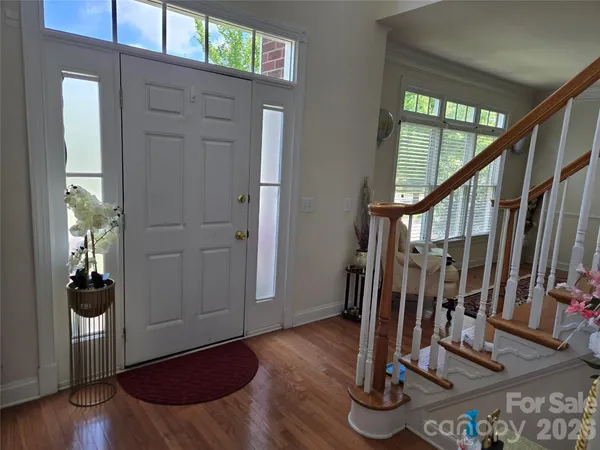 a view of front door with wooden floor and stairs