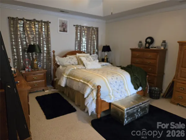 a bedroom with a bed a dresser and window