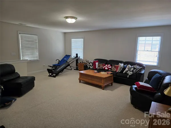 a living room with furniture gym equipment and a window