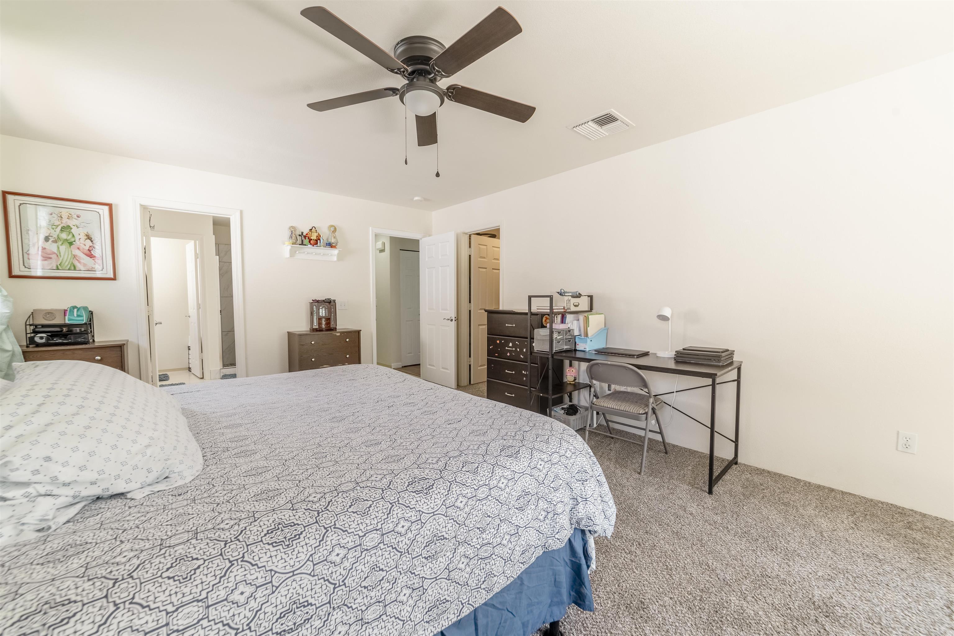 121 Molehulehu Loop Kahului, HI 96732 - Photo 20 of 43 a spacious bedroom with a bed a dresser and a chandelier
