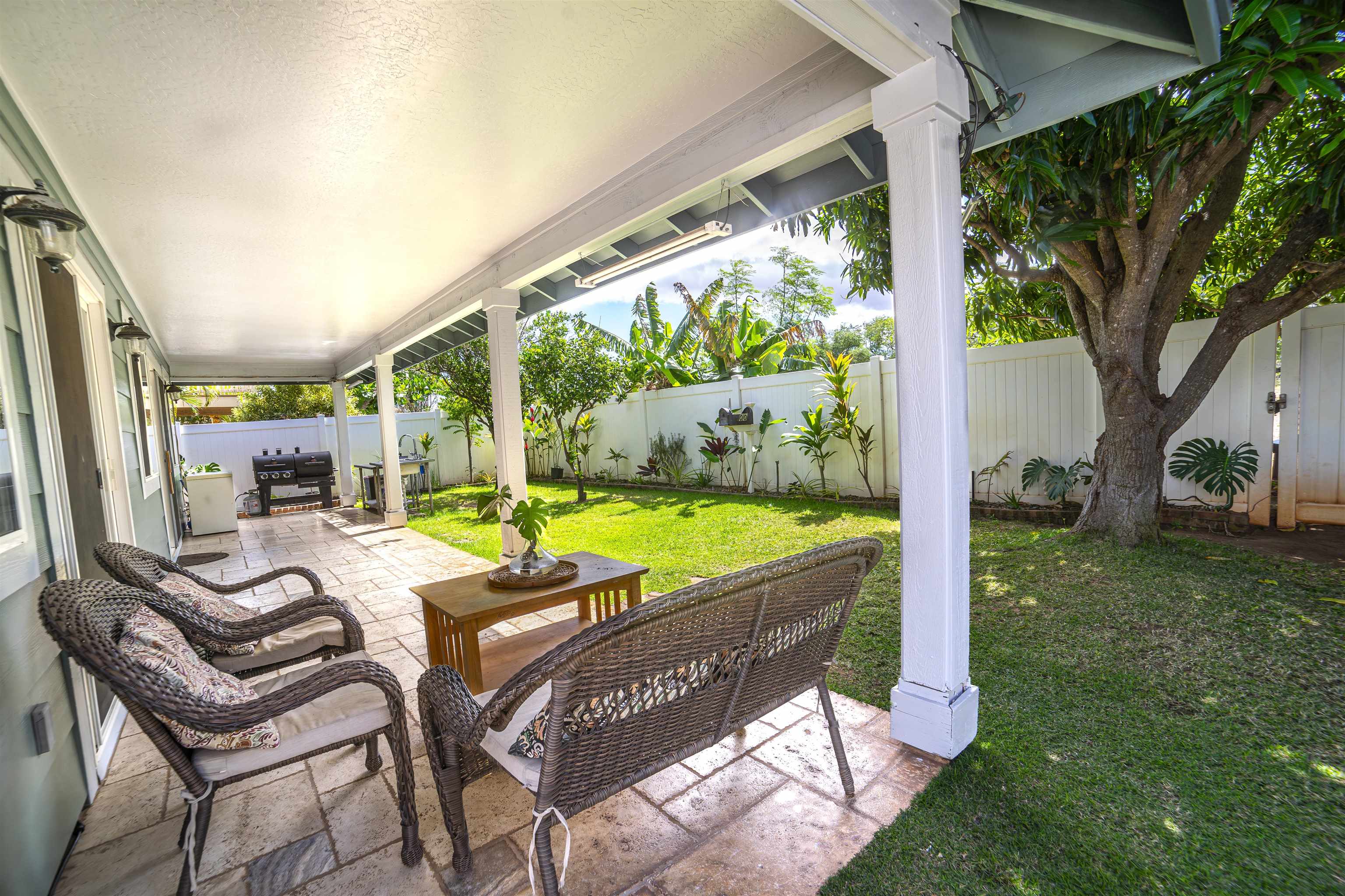 121 Molehulehu Loop Kahului, HI 96732 - Photo 36 of 43 a view of a patio with table and chairs potted plants with wooden floor and fence