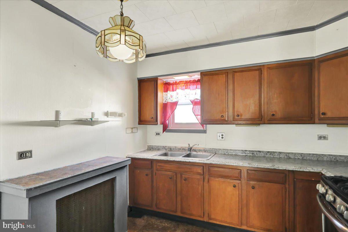 1129 East Greenwich Street Reading, PA 19604 - Photo 17 of 33 a kitchen with granite countertop a sink a stove and cabinets