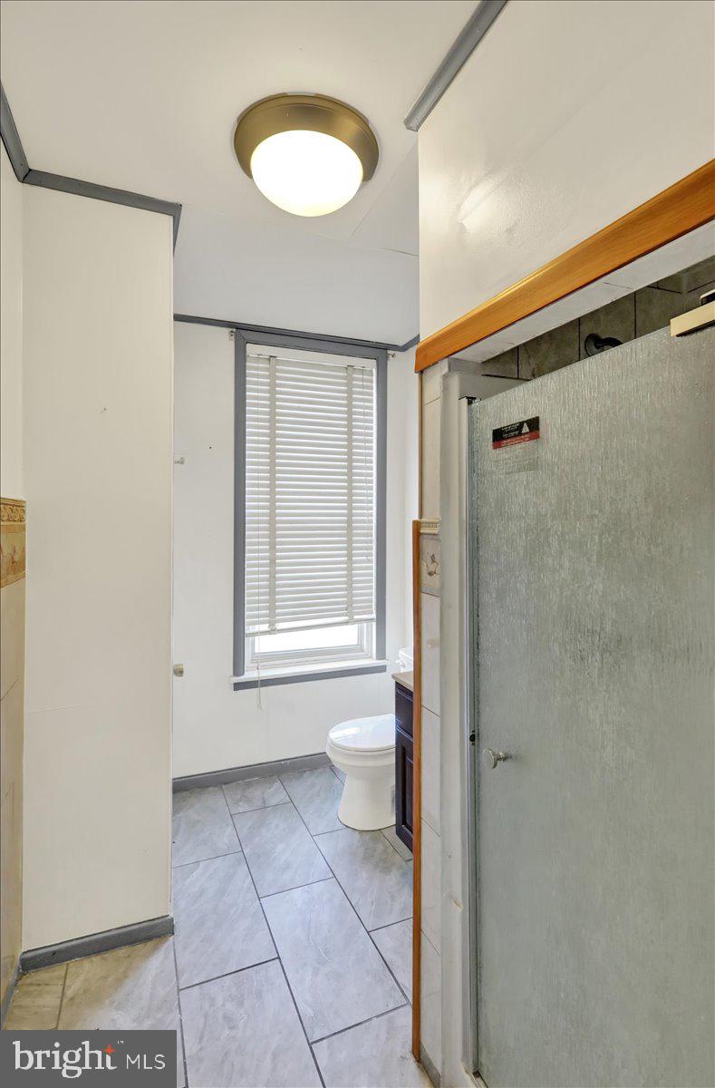 1129 East Greenwich Street Reading, PA 19604 - Photo 21 of 33 a bathroom with a toilet a sink and a window