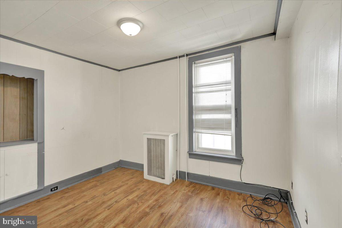 1129 East Greenwich Street Reading, PA 19604 - Photo 23 of 33 an empty room with wooden floor cabinet and windows
