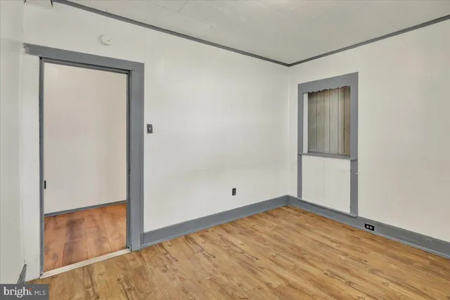 a view of an empty room with window and cabinet