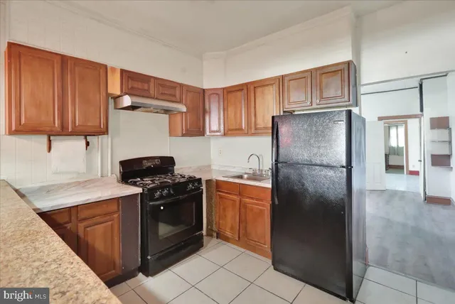 a kitchen with a stove a refrigerator and a cabinets