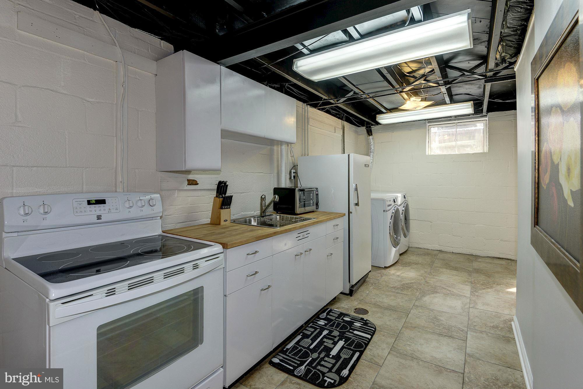 1301 Chalmers Road Silver Spring, MD 20903 - Photo 24 of 28 a kitchen with a stove and white cabinets