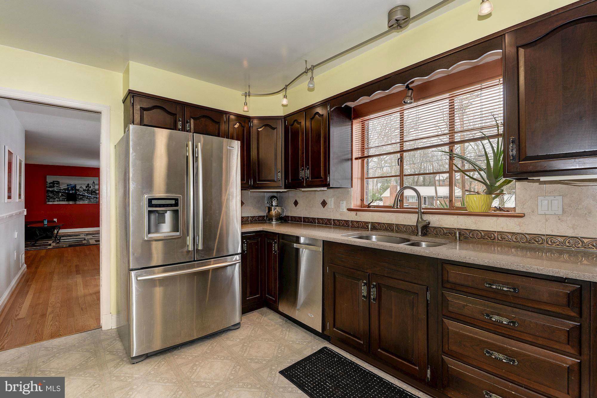 1301 Chalmers Road Silver Spring, MD 20903 - Photo 4 of 28 a kitchen with granite countertop stainless steel appliances a sink cabinets and a window