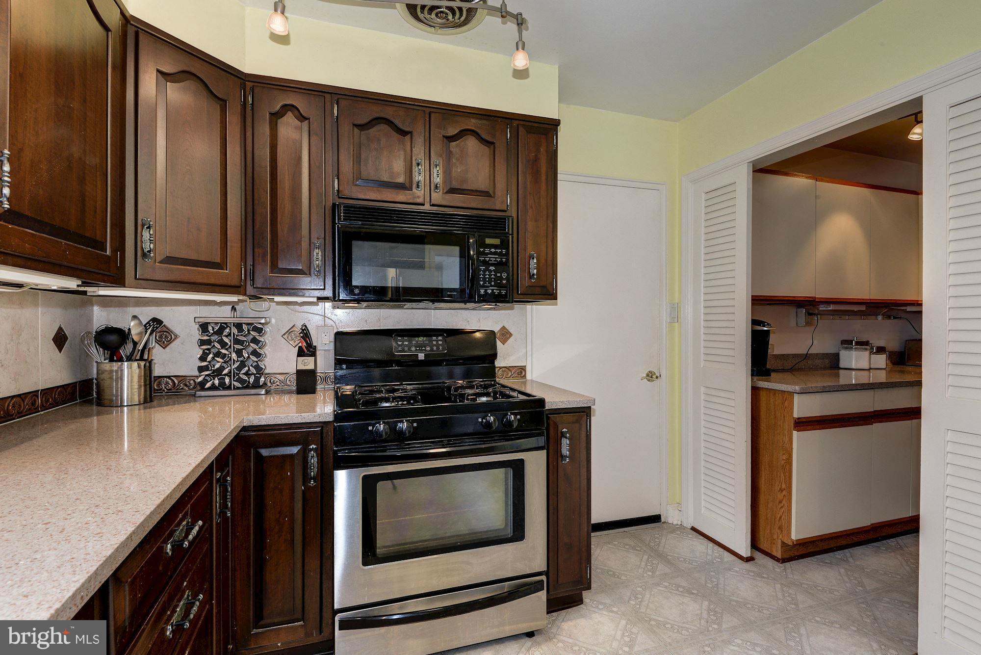 1301 Chalmers Road Silver Spring, MD 20903 - Photo 5 of 28 a kitchen with stainless steel appliances a stove microwave and sink