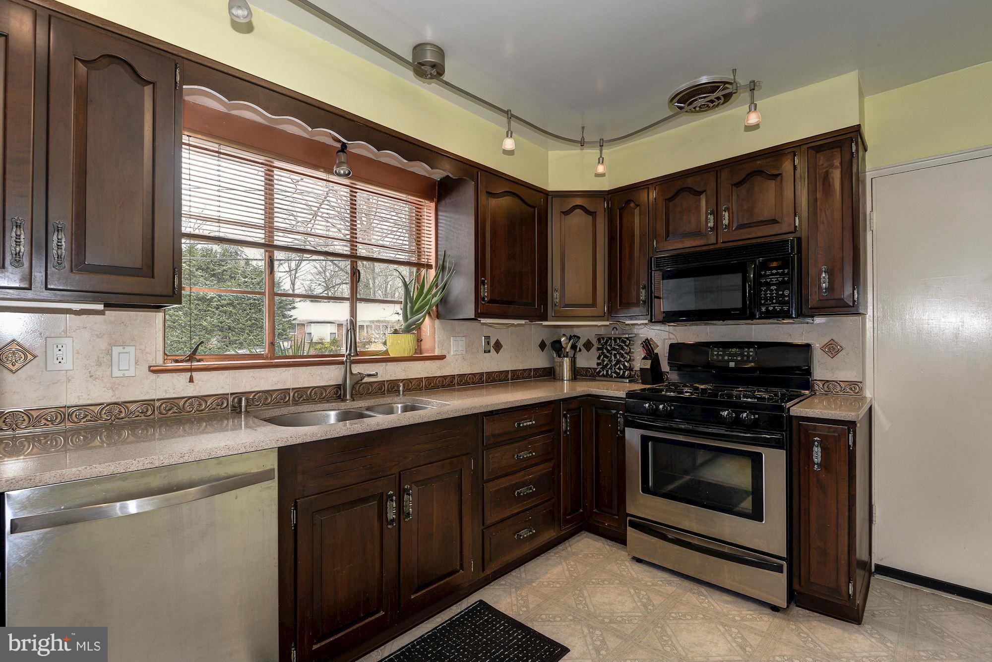 1301 Chalmers Road Silver Spring, MD 20903 - Photo 6 of 28 a kitchen with stainless steel appliances granite countertop a sink a stove a microwave and cabinets