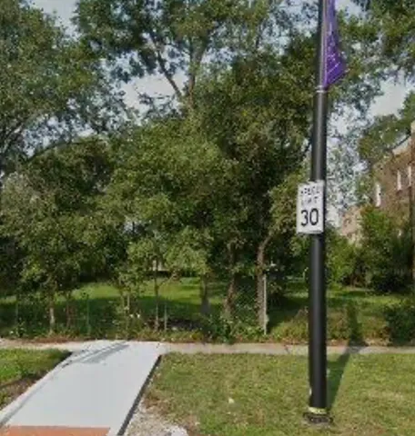 a street sign on a sidewalk next to a road