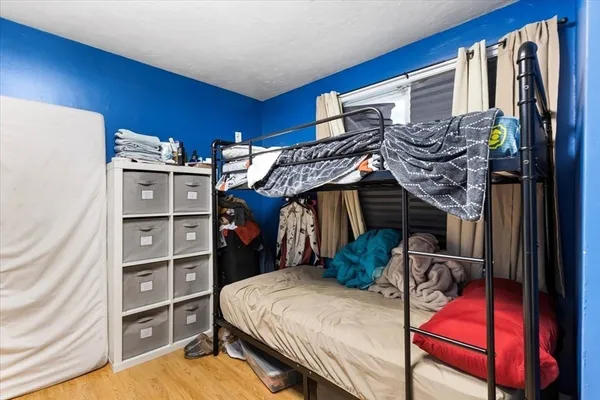 a bedroom with a bed and wooden floor