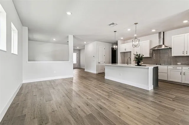 an empty room with wooden floor and glass door
