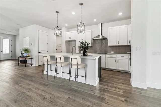 a view of kitchen with stainless steel appliances kitchen island a stove a refrigerator a center island a stove and white cabinets