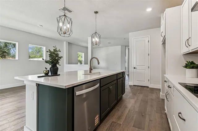 a kitchen with granite countertop a sink a stove and cabinets