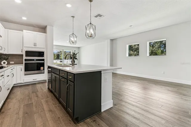 a view of a kitchen with wooden floor and a window