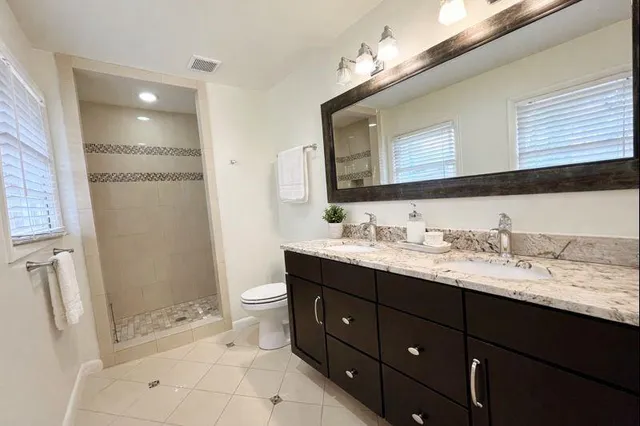 a bathroom with a granite countertop sink toilet and shower