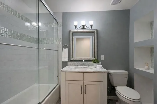 a bathroom with a sink toilet vanity and shower