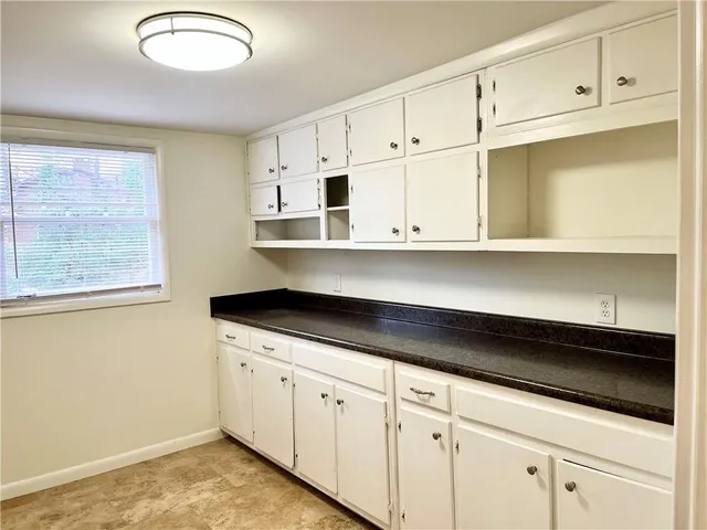 a kitchen with granite countertop white cabinets and a sink