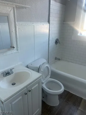 a bathroom with a tub a toilet and a shower