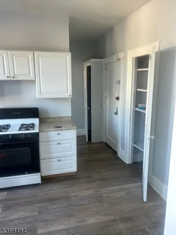 a kitchen with granite countertop white cabinets and white appliances