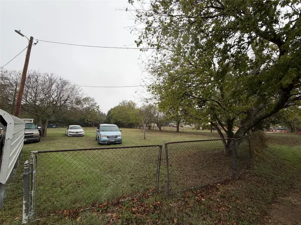 a view of a yard with cars parked on the road