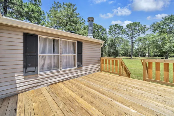a view of backyard with deck and outdoor seating
