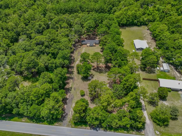 an aerial view of a house with a yard and large trees