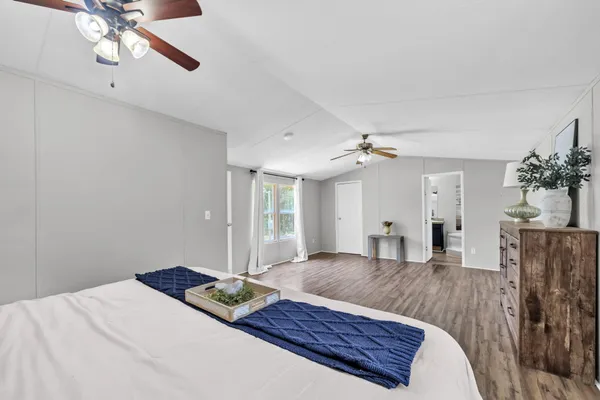a bedroom with a large bed and a chandelier