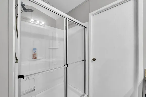 a bathroom with a glass shower door and a mirror