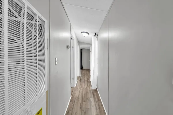 a view of hallway with wooden floor