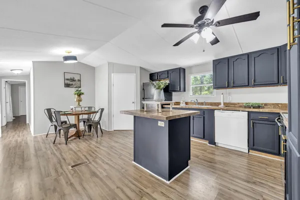 a kitchen with a table chairs microwave and cabinets