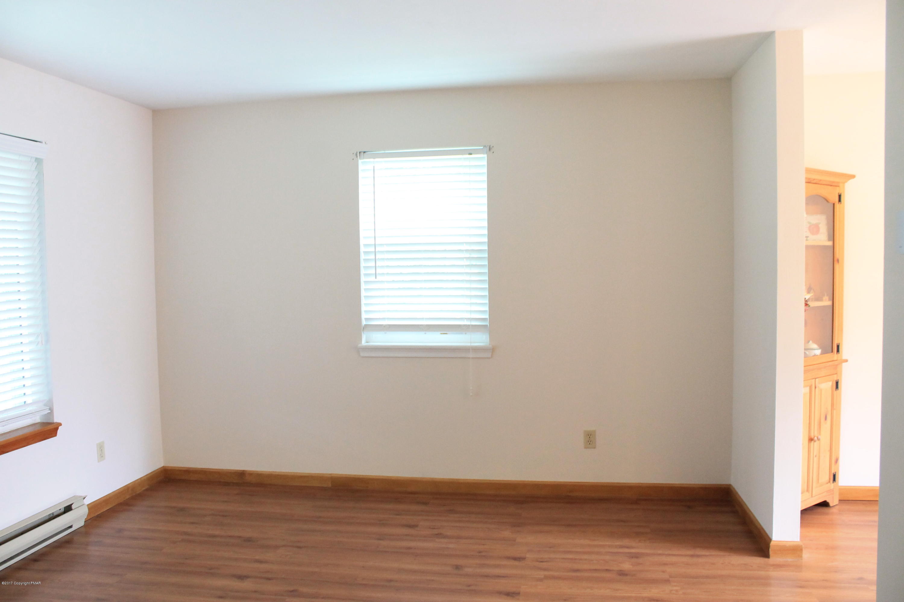 169 Ryan Road Blakeslee, PA 18610 - Photo 8 of 22 an empty room with wooden floor and windows