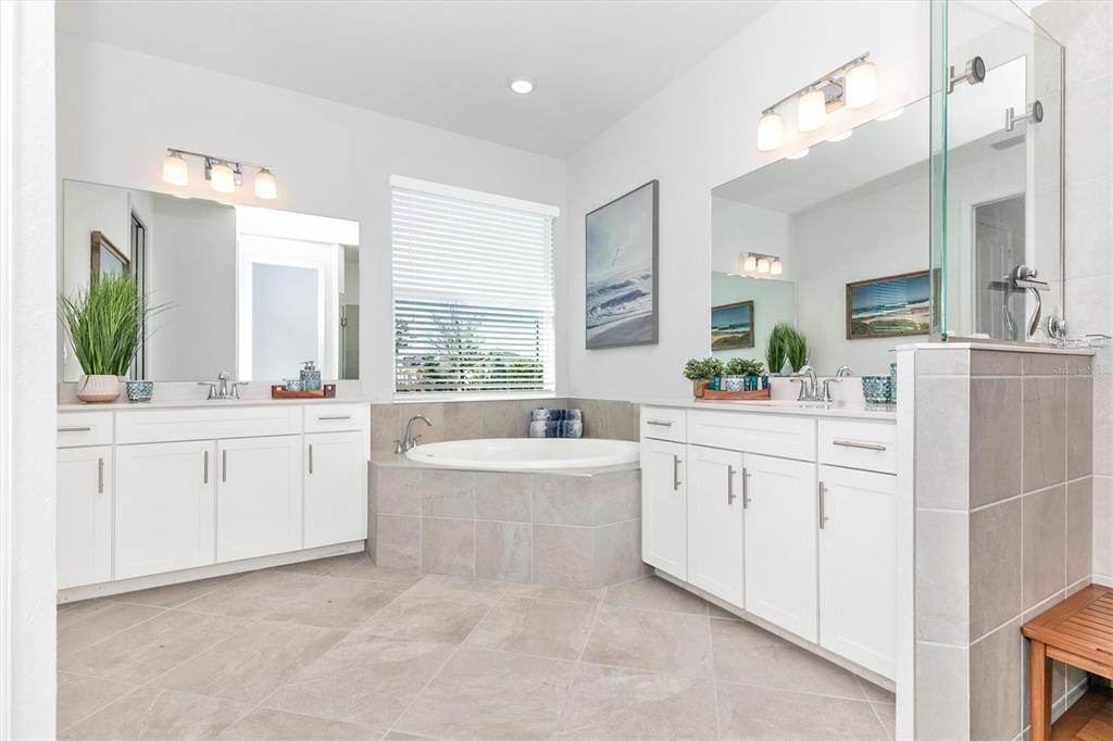 17180 Jadestone Court Venice, FL 34293 - Photo 23 of 98 a spacious en suite bathroom with a granite countertop double vanity sink a mirror and a bathtub