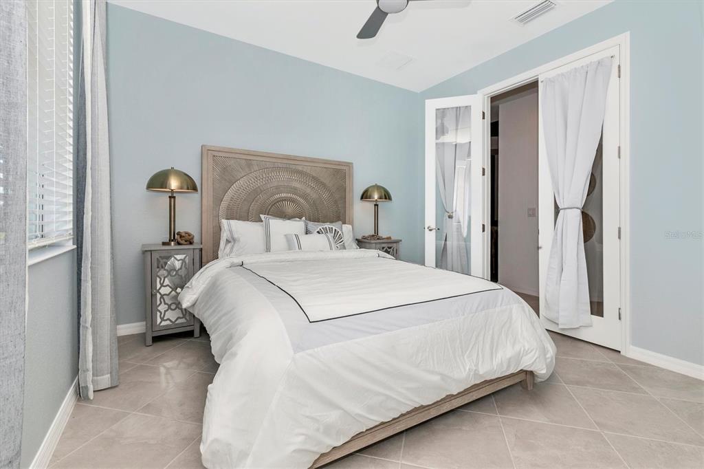 17180 Jadestone Court Venice, FL 34293 - Photo 28 of 98 a bedroom with a bed and a mirror
