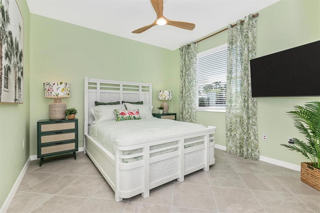 17180 Jadestone Court Venice, FL 34293 - Photo 32 of 98 a bedroom with a bed and a flat screen tv