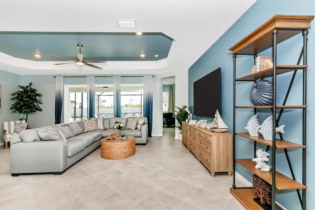 17180 Jadestone Court Venice, FL 34293 - Photo 10 of 98 a living room with furniture a flat screen tv and a chandelier