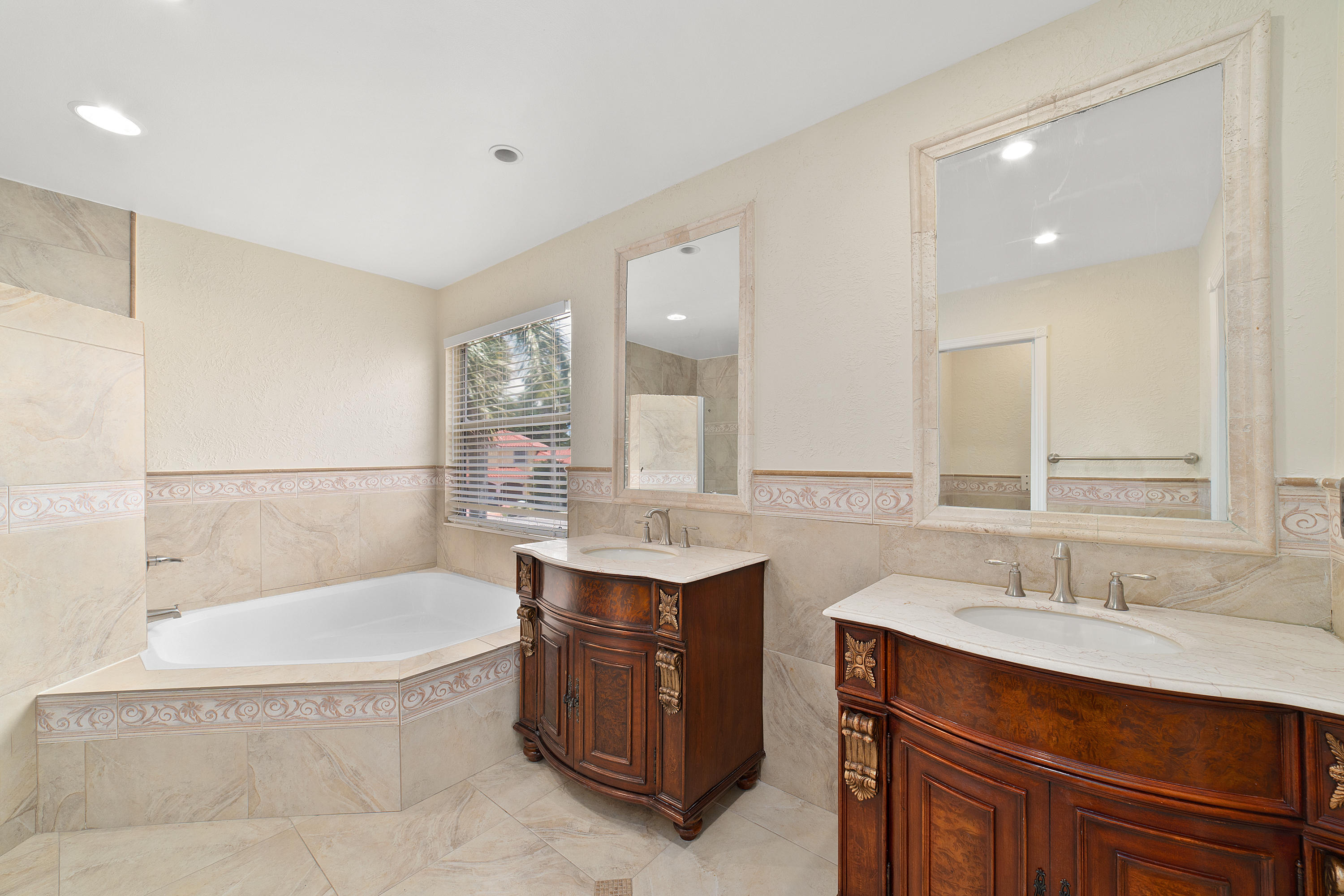 19554 Black Olive Lane Boca Raton, FL 33498 - Photo 22 of 40 a bathroom with a tub a sink double vanity and mirror