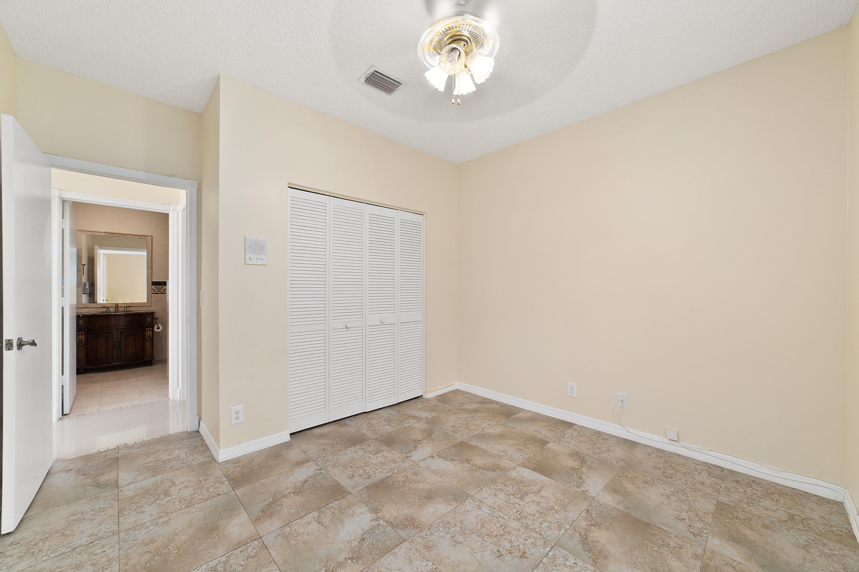 19554 Black Olive Lane Boca Raton, FL 33498 - Photo 31 of 40 an empty room with a chandelier fan and windows