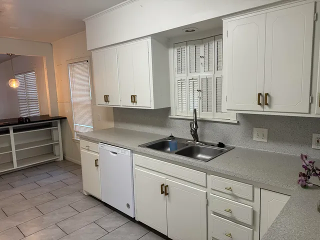 a kitchen with granite countertop white cabinets and white appliances