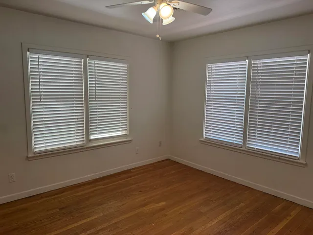 an empty room with wooden floor and a window