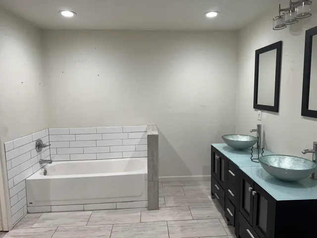 a bathroom with a double vanity sink and a bathtub