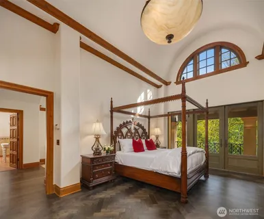 a bedroom with a bed a window and a chandelier