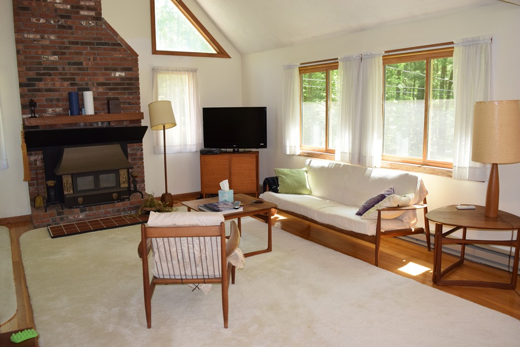 336 Sterling Road Holden, MA 01522 - Photo 9 of 16 a living room with furniture a flat screen tv and a fireplace